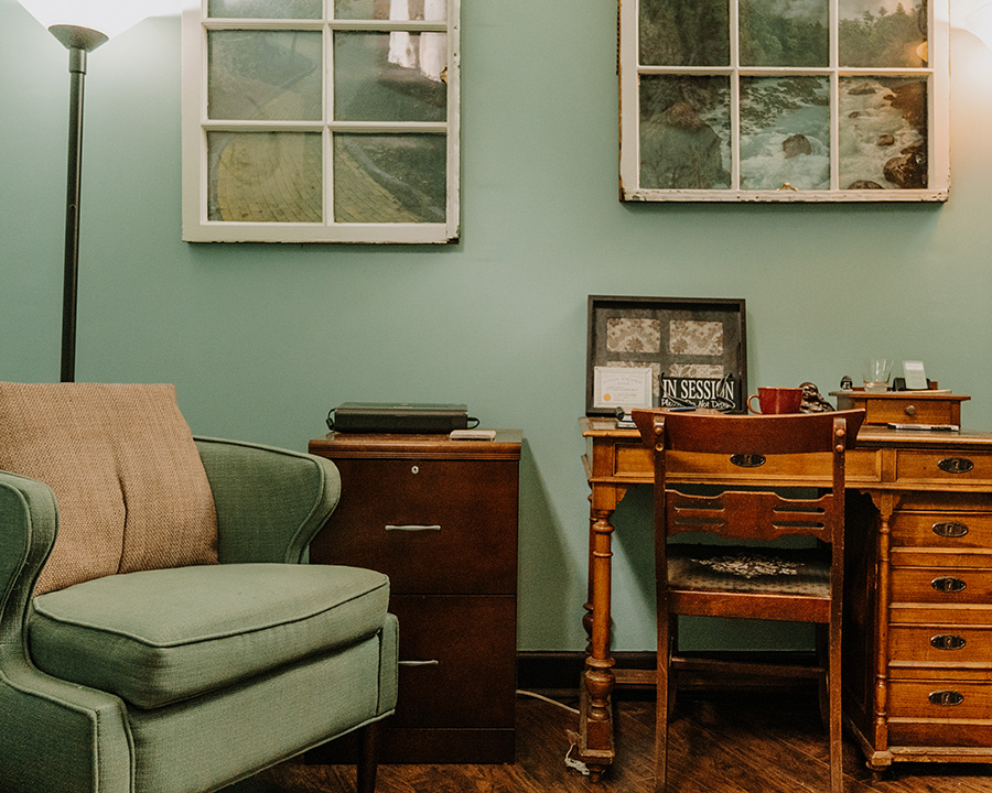 Kathryn Stinson's therapy office with green couch and wooden desk
