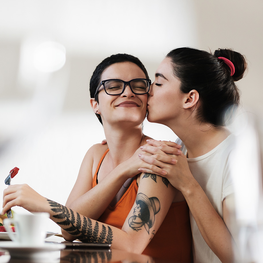 Lesbian couple having breakfast discussing therapy for unconventional relationships in St. Louis, MO