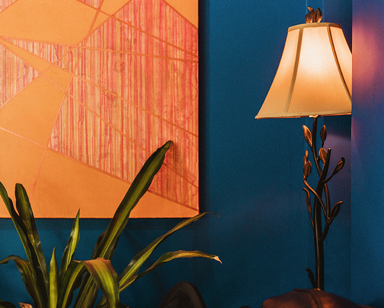 Orange painting, floor lamp and plant in the office of Kathryn Stinson, LPC